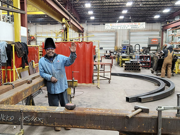 Worker in welding shop waving