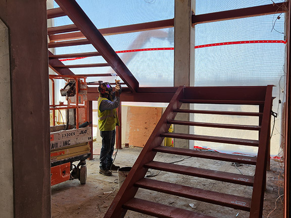 Worker installing two-part staircase