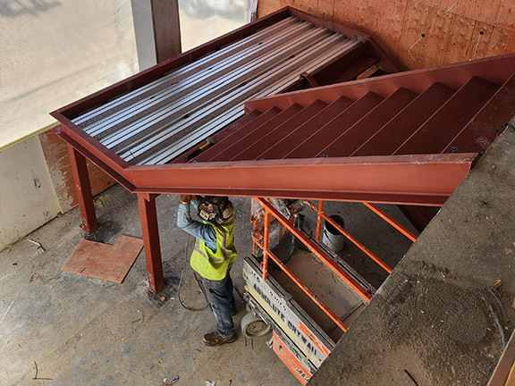 Worker installing two-part staircase